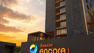 En moderne bygning med et skilt, der viser 'Ramada Encore by Wyndham' og 'Ayodhya Takpura', der angiver et hotel.