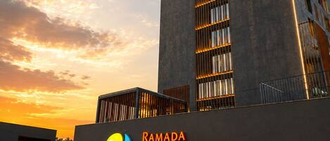 En moderne bygning med et skilt, der viser 'Ramada Encore by Wyndham' og 'Ayodhya Takpura', der angiver et hotel.