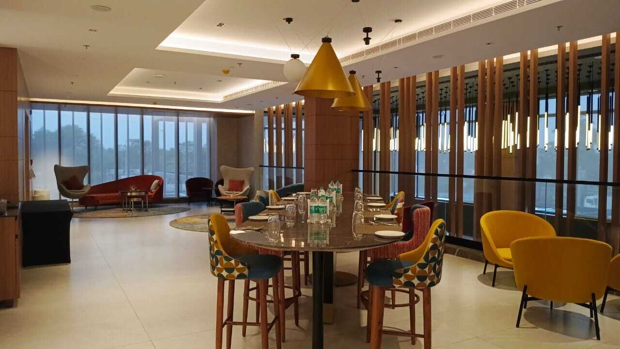 A modern dining area with a round table, chairs, and pendant lighting.