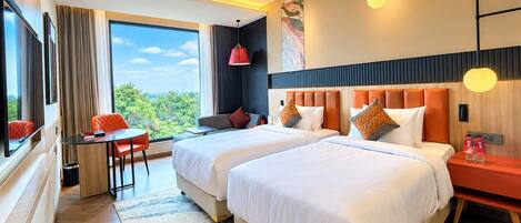 Une chambre d’hôtel avec deux lits, un bureau et une vue sur l’extérieur.