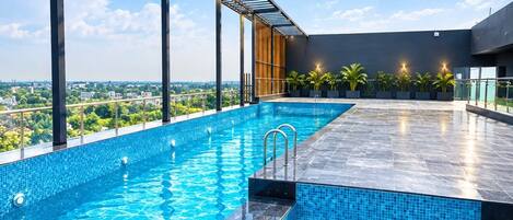 A rooftop swimming pool with a clear view of the cityscape.