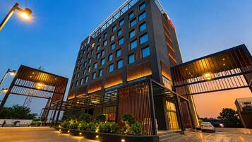 A modern hotel with a prominent entrance, multiple floors, and a well-lit facade.