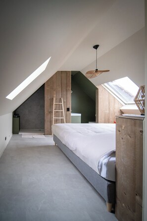 A bedroom with a sloped ceiling, skylight, wooden panel wall, a bed, a ladder, and a desk. - A warm, cozy vacation home where you always feel right at home (Poperinge)