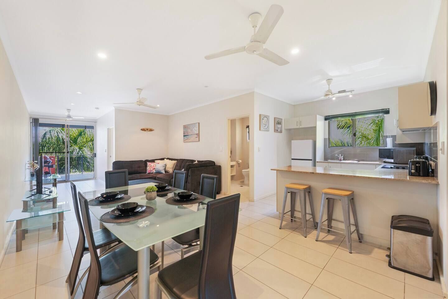 A modern apartment with a dining area, kitchen, and living room.