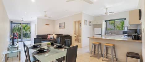 A modern apartment with a dining area, kitchen, and living room.