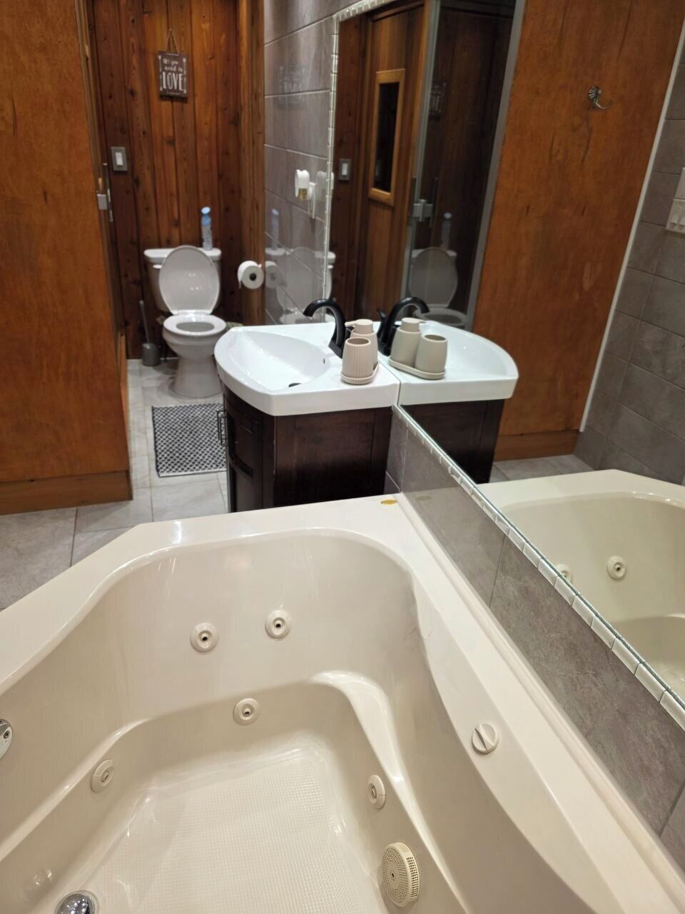 Un baño con bañera, dos lavamanos, inodoro y zona de ducha.