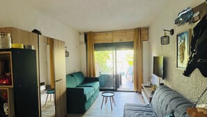 A compact living space with a sofa, a small table, a cabinet, and a television. - Perfect for couples—just a 3-minute walk from Liscia Beach. Pets allowed. (Calcatoggio)