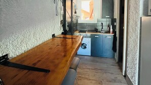 A compact kitchen with a wooden table, a washing machine, and a blue cabinet. - Perfect for couples—just a 3-minute walk from Liscia Beach. Pets allowed. (Calcatoggio)
