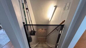 Een trap met een zwart tapijt en een metalen leuning, plus een veiligheidsnet.