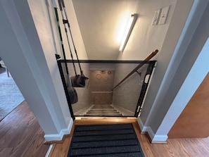 A staircase with a black carpet runner, a metal handrail, and a mesh safety barrier.