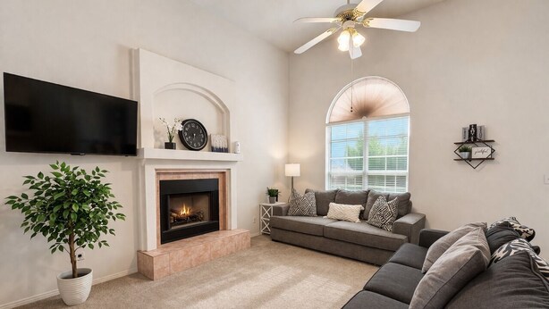 A living room with a fireplace, a sofa, a television, and a ceiling fan. - 3-bedroom house, great location. Shopping and dining nearby (El Paso)