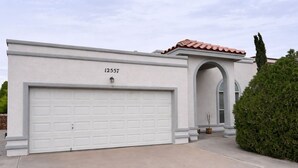 A modern house with a white garage, a red-tiled roof, and a large arched doorway. - 3-bedroom house, great location. Shopping and dining nearby (El Paso)