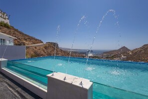 A swimming pool with water jets, a clear blue sky, and a mountainous landscape in the background. - New Modern Estate 20Bd, Gym, Sauna, Massage, Games (Cabo San Lucas)
