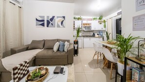 A modern living room with a sofa, a coffee table, and a dining area with chairs and a table. - Casa Perla - Nueva San Miguel P114-6 (San Miguel)