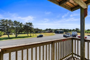 A parking lot with vehicles, a building, and trees in the background.