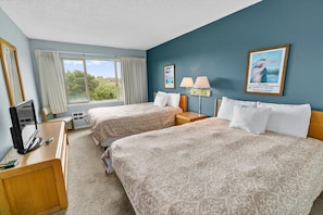 A hotel room with two beds, a desk with a television, and a window with curtains. - Pet-Friendly Family Suite for 6 with Kitchen (Ocean Shores)