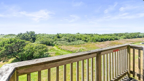 Een balkon met uitzicht op een bebost landschap.