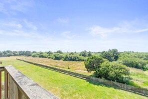 A fenced outdoor area with a grassy field and trees in the background.