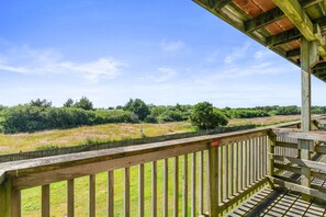 A wooden deck with a view of a grassy field and trees. - Pet-Friendly Family Suite For 6 - Pool & Hot Tub! (Ocean Shores)