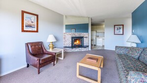 Una sala de estar con chimenea, un sillón de cuero, un sofá y una mesa de centro.