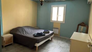 Tabla de planchar con plancha, internet y ropa de cama
