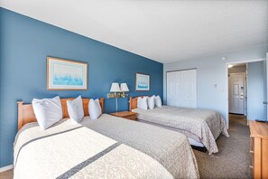 A hotel room with two beds, a nightstand with lamps, a door, and a framed picture on the wall. - 1-Bedroom Suite For 6 with Kitchen & Pool Access! (Ocean Shores)
