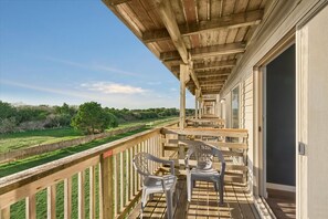 A wooden balcony with a view of a grassy field and trees. - Pet-Friendly King Bed Studio with Pool & Hot Tub! (Ocean Shores)