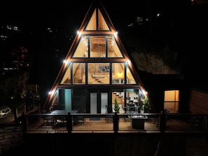 Ein mehrgeschossiges Holzhaus mit einem dreieckigen Dach, großen Fenstern und einem Balkon.