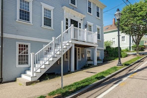 A two-story building with a white staircase leading to a balcony.