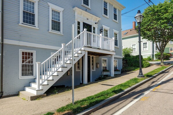 A two-story building with a white staircase leading to a balcony.