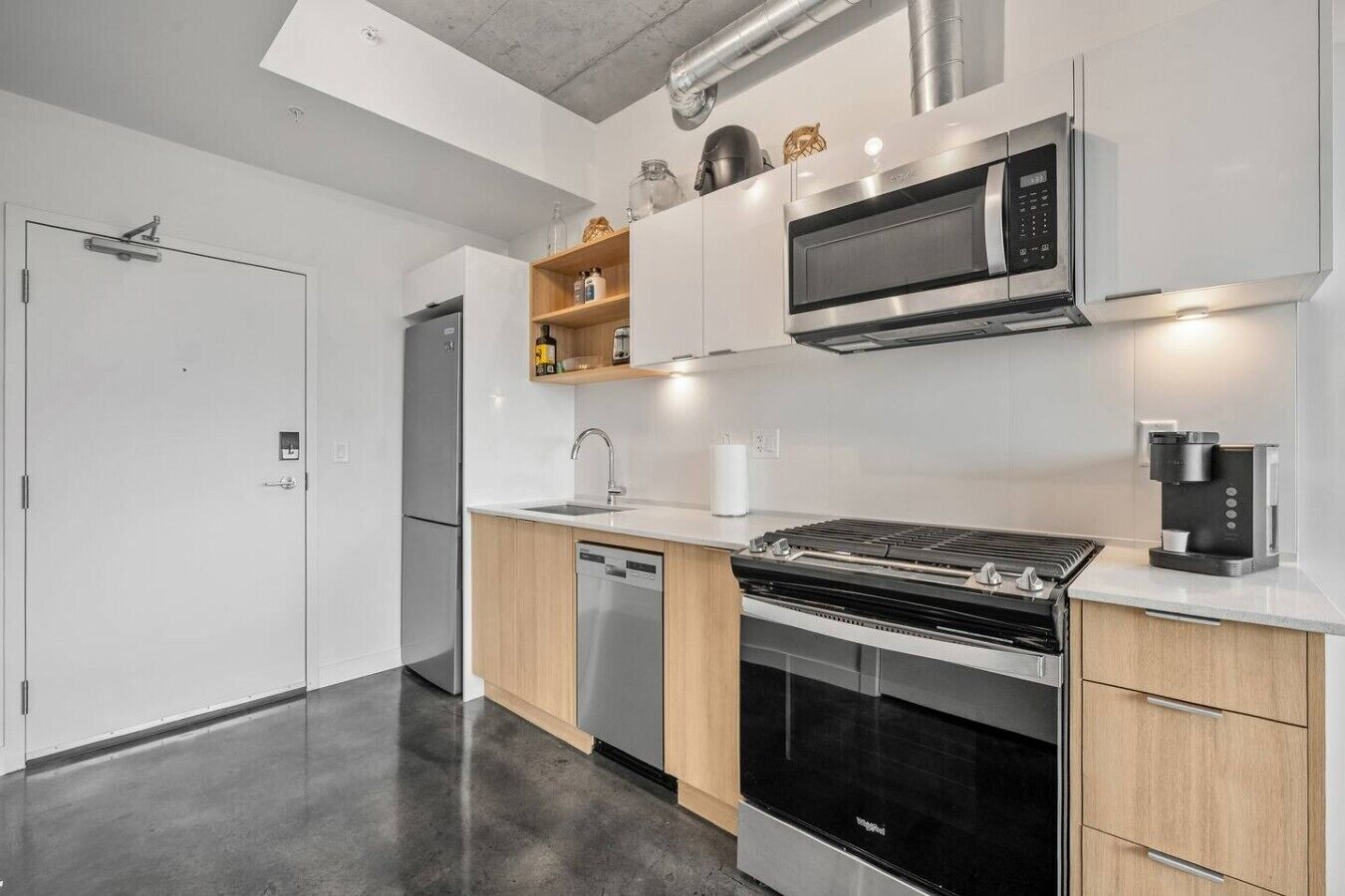 Eine moderne Küche mit eingebautem Backofen, Mikrowelle und Kaffeemaschine.