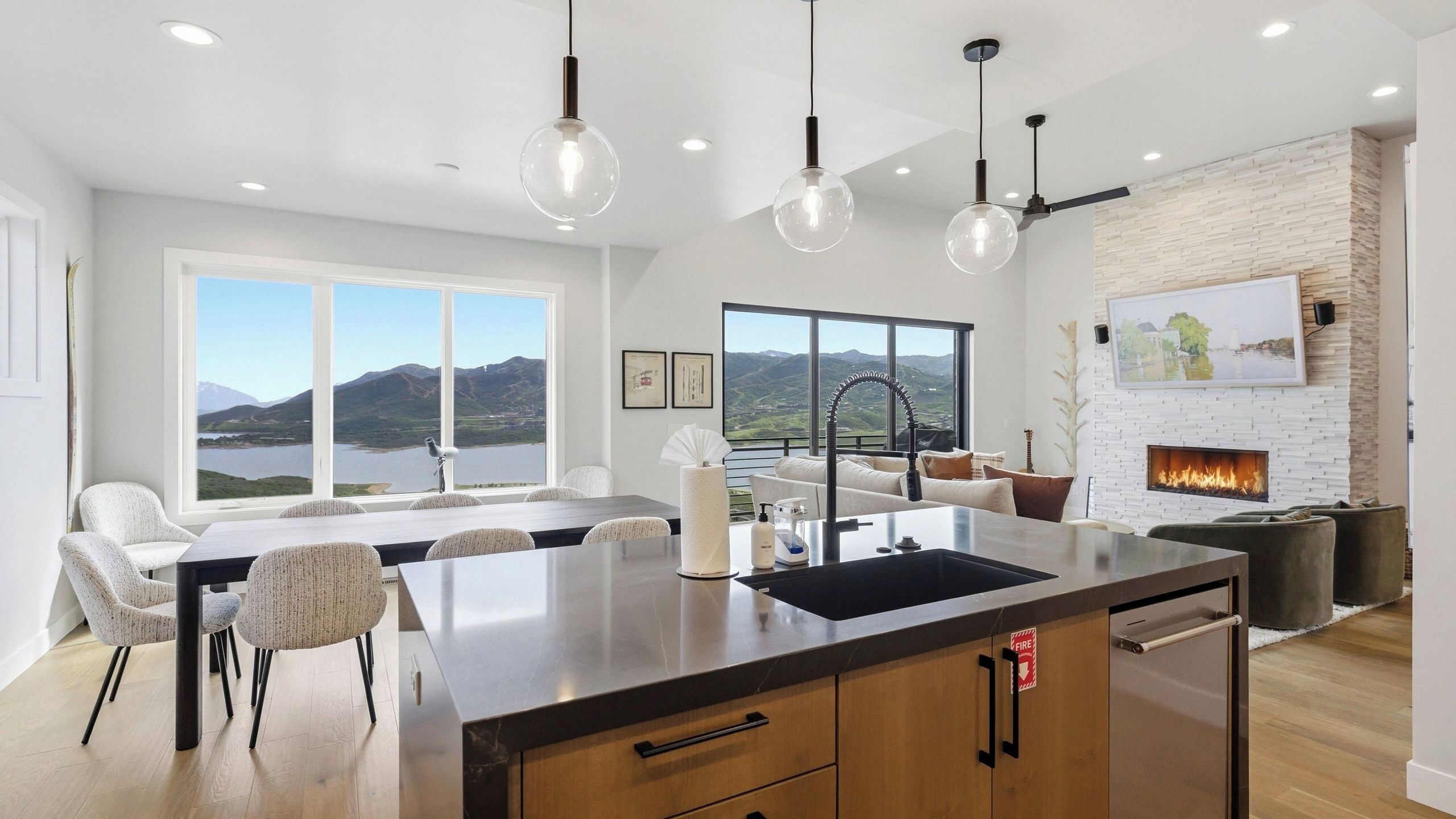 Una cocina moderna con una isla grande, un comedor con vistas y una chimenea.