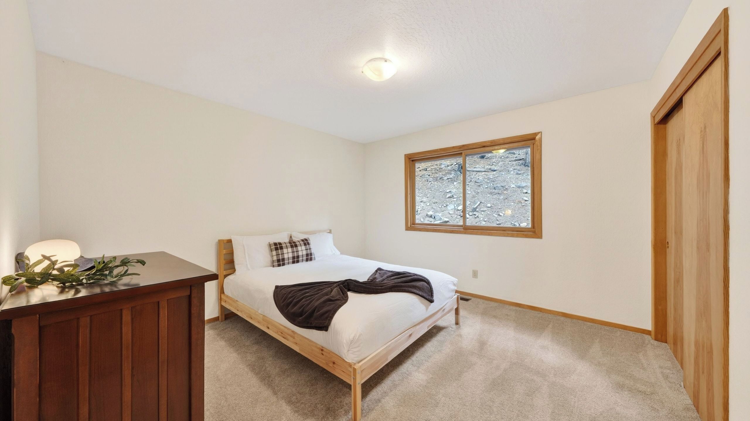Une chambre à coucher avec un lit, un bureau, une fenêtre et une porte.
