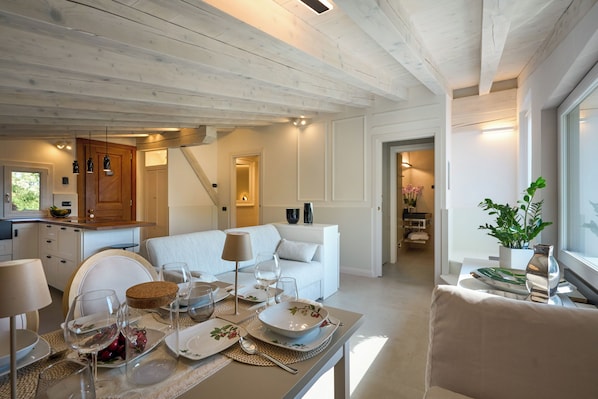A modern interior with a dining area, a sofa, and a kitchen.