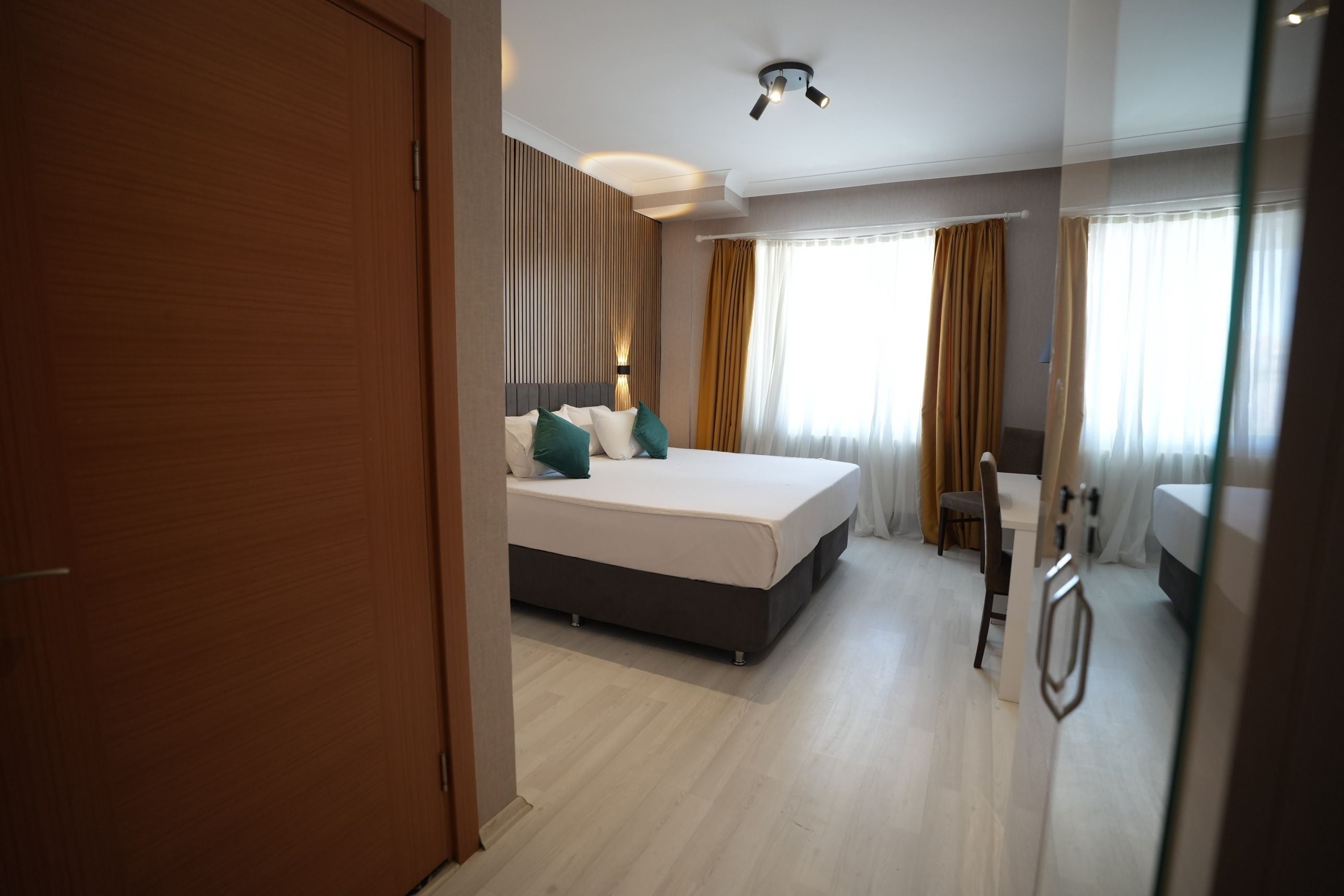 Une chambre d’hôtel avec un lit, un bureau et une chaise.