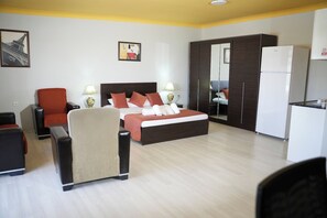 A hotel room with a bed, a desk, a chair, a wardrobe, and a refrigerator. - DORA BEYTEPE HOTEL (Ankara)