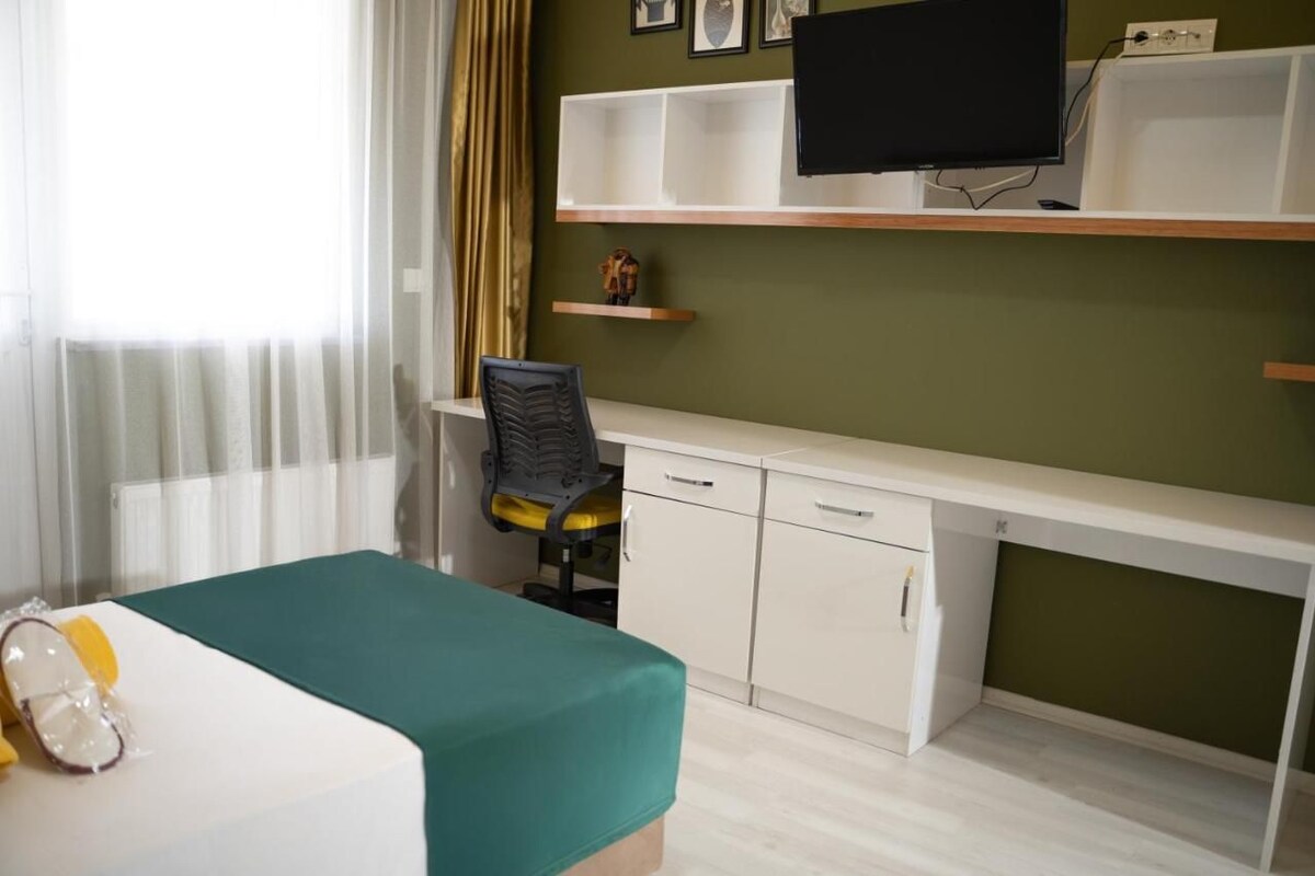 Una habitación de hotel con cama, escritorio, silla y televisor.