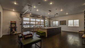 Ein geräumiges Zimmer mit großem Fenster, einer Küchenzeile, einer Bar und einem Billardtisch.
