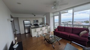 Eine moderne Wohnung mit Küche, Essbereich und Wohnzimmer mit Blick auf die Stadt.