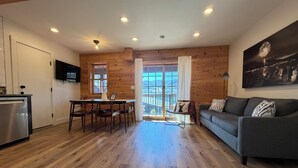 A modern living space with a kitchen, dining area, and a sofa.