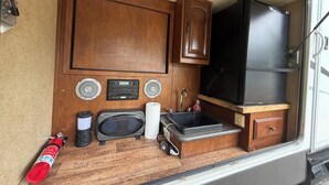 Une petite cuisine équipée comprenant un four à micro-ondes, un évier et des placards de rangement.