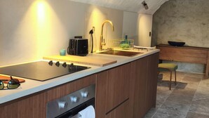 Uma cozinha moderna com forno embutido, pia e fogão.