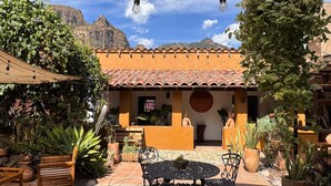 A courtyard with a patio, outdoor seating, and potted plants. - Umbral (Tepoztlan)