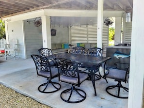 An outdoor patio with a table and chairs, a sofa, and a grill. - Waterfront Cottage in the Keys - 2 bed 2 bath, pet friendly (Cudjoe Key)