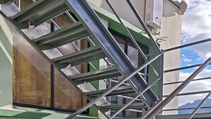 Un escalier en métal, doté d’une rampe, menant à l’étage supérieur.