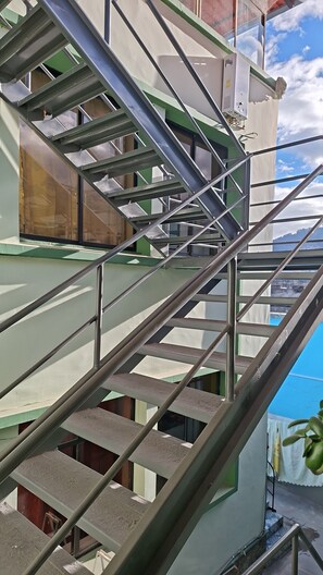 Eine Metalltreppe mit Handlauf, die zu einer oberen Etage führt.