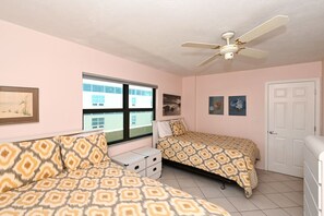 A bedroom with two beds, a ceiling fan, a window, and a door. - Paradise Awaits Siesta Key #1 Beach (Siesta Key)