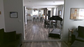 A modern kitchen with white cabinets, a central island, and bar stools.