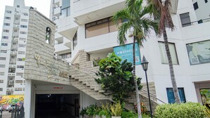 Um edifício com fachada de pedra, uma palmeira e uma placa com 'Morpheus'.