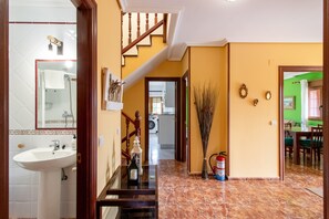 Ein Flur mit Treppe, Waschbecken und Feuerlöscher.